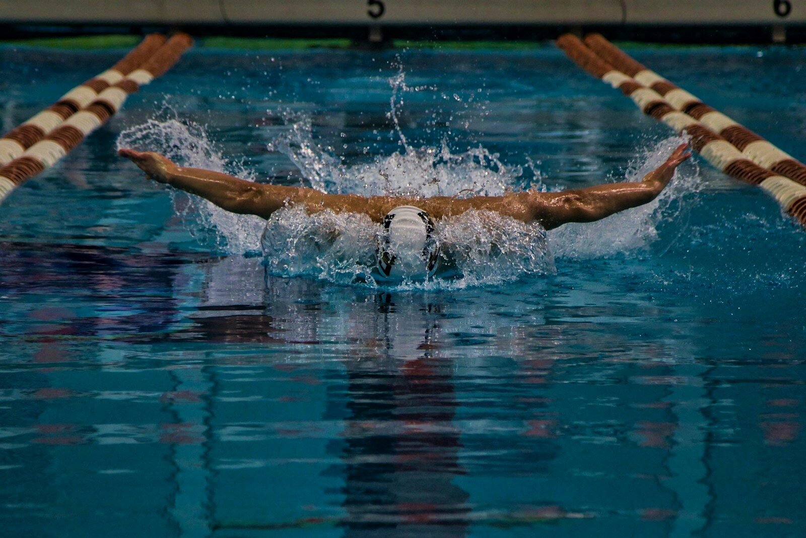 a man swimming in a pool with a swimming board